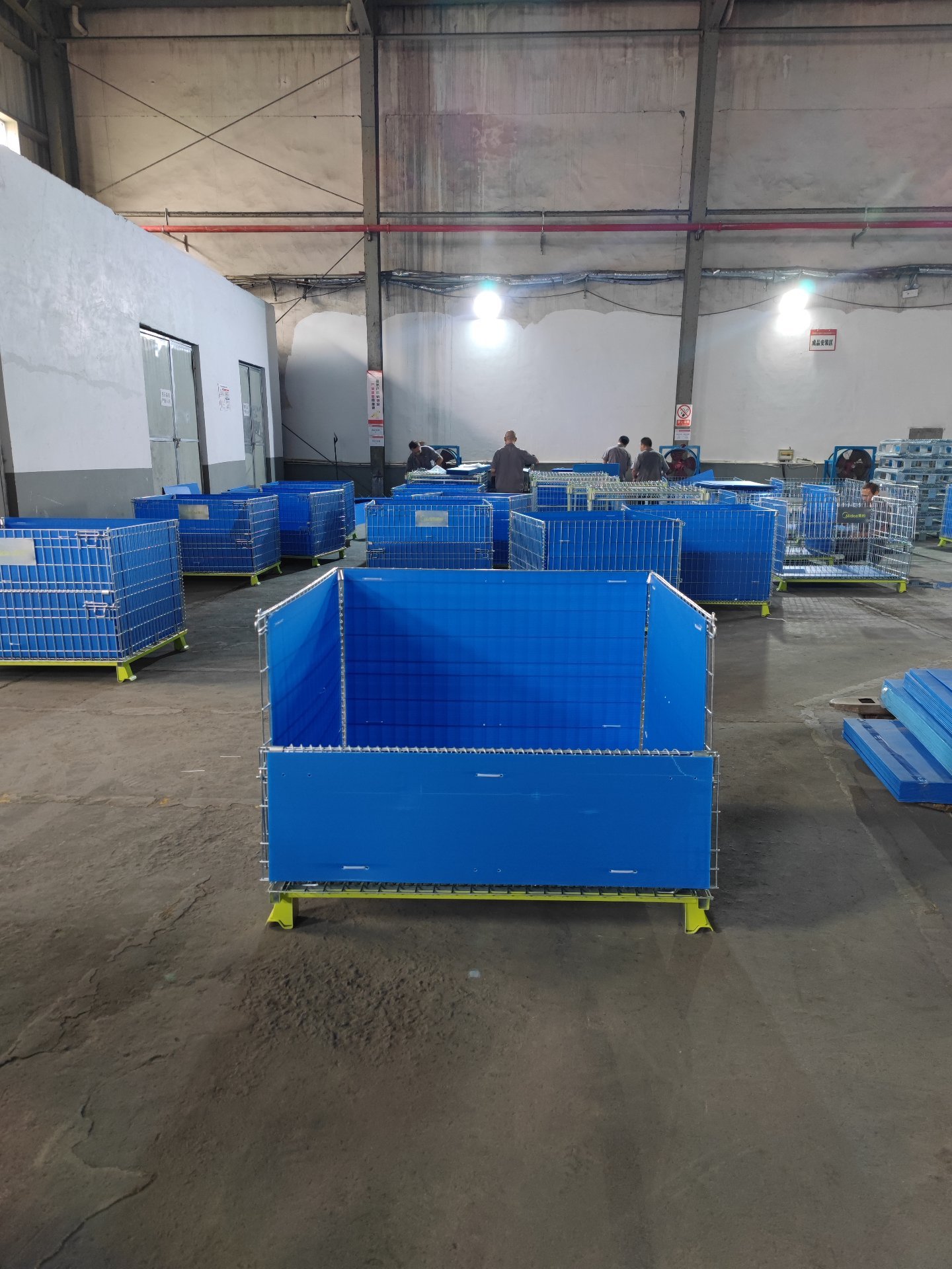 Multiple completed lined wire containers arranged in factory warehouse