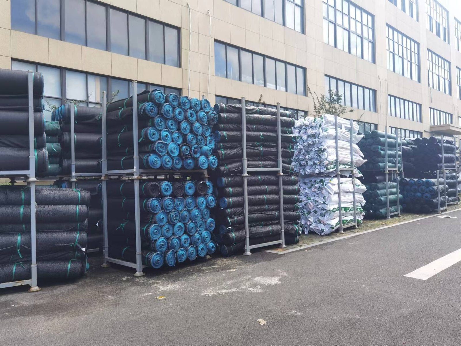 Stackable textile roll storage racks loaded with fabric rolls